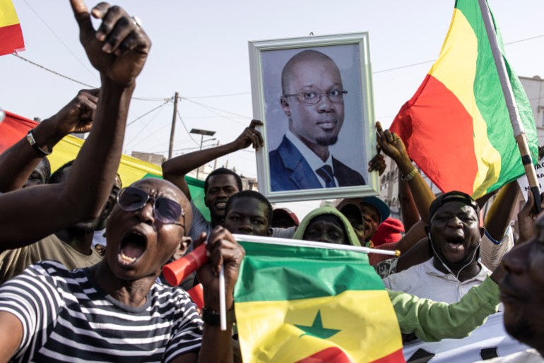 Opposition supporters sing and dance during a meeting two days before the trial of one of the leaders, Ousmane Sonko, in Dakar on March 14, 2023. (Photo by JOHN WESSELS / AFP)